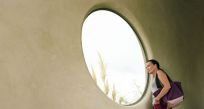 woman in front of a big round window