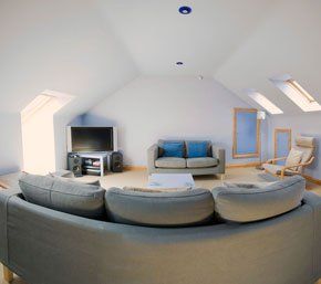 modern looking loft conversion painting white with grey sofas