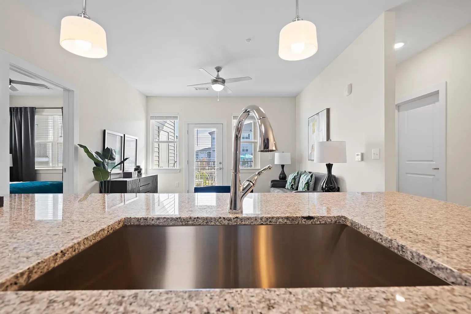 Open-concept kitchen with granite countertop island and stainless-steel sink at Graces Reserve Apartments in Kannapolis, NC.