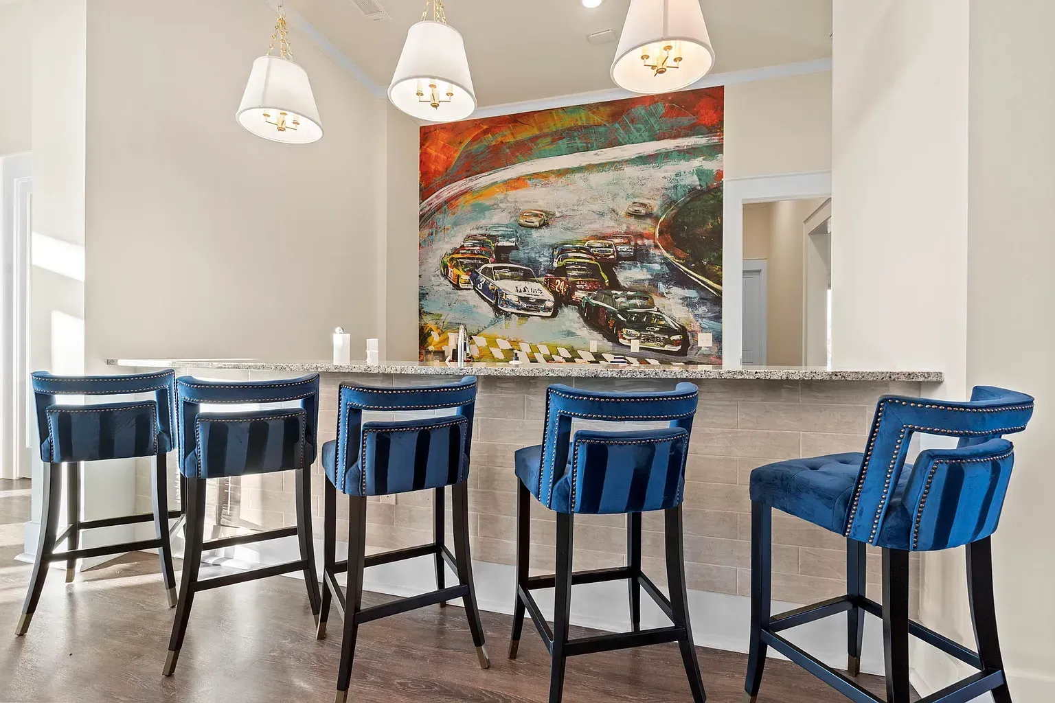 Bar counter with blue upholstered stools in a community lounge at Graces Reserve Apartments in Kannapolis, NC.