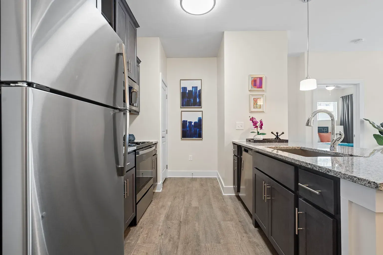 Modern apartment kitchen with stainless steel appliances, granite countertops, and an island at Graces Reserve Apartments in Kannapolis, NC.