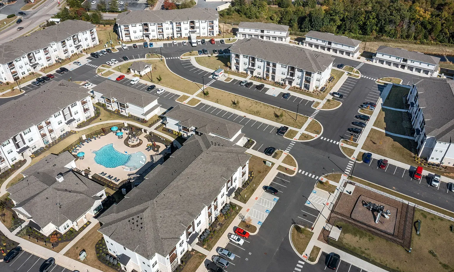 Aerial view of a multi-building apartment community with a central pool and parking at Graces Reserve Apartments in Kannapolis, NC.
