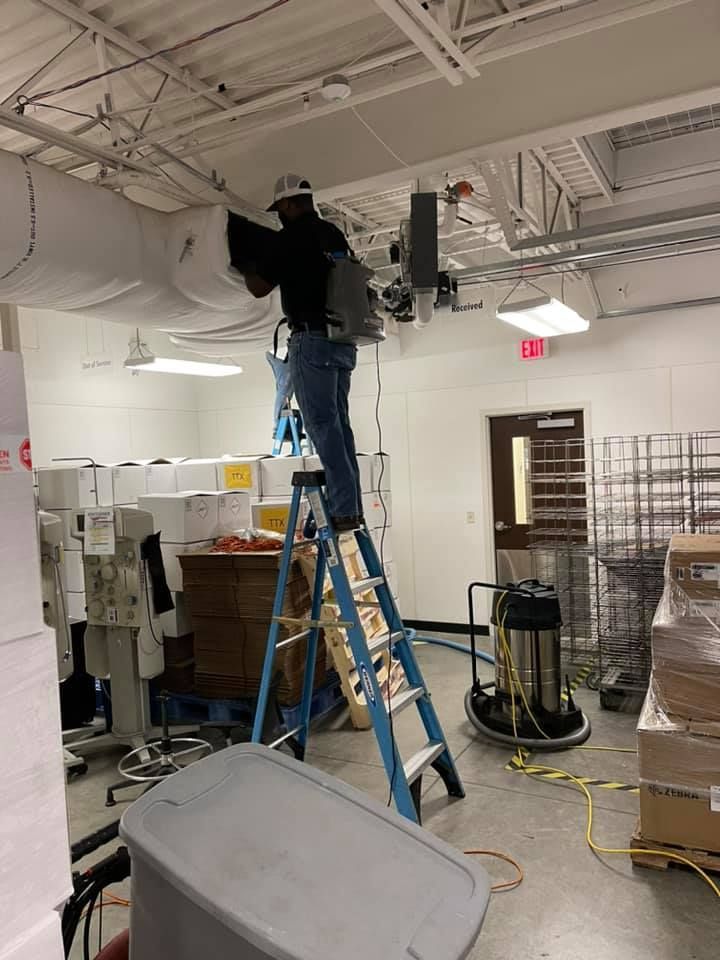 A man is standing on a ladder in a room.