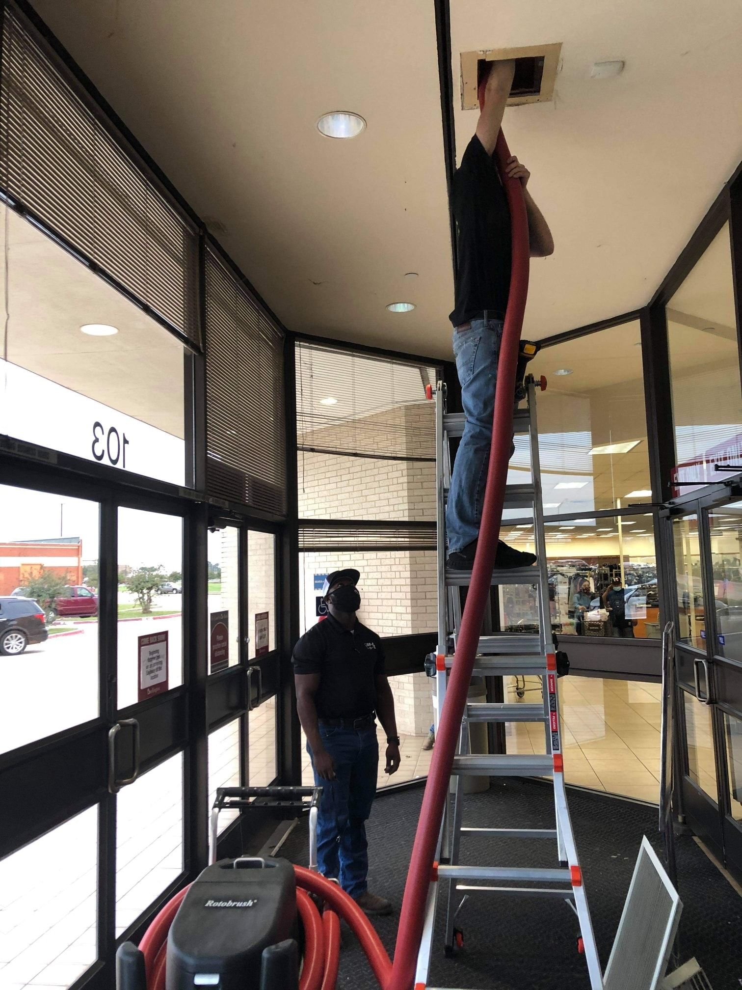 A man is standing on a ladder in a building.