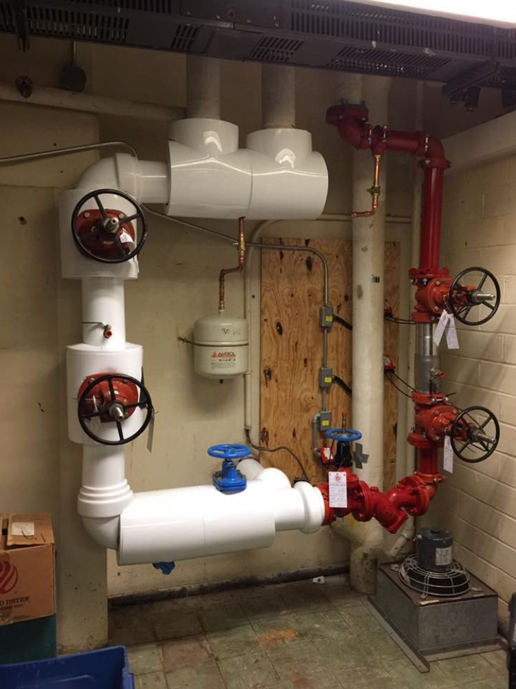 A room with a lot of pipes and valves on the wall.
