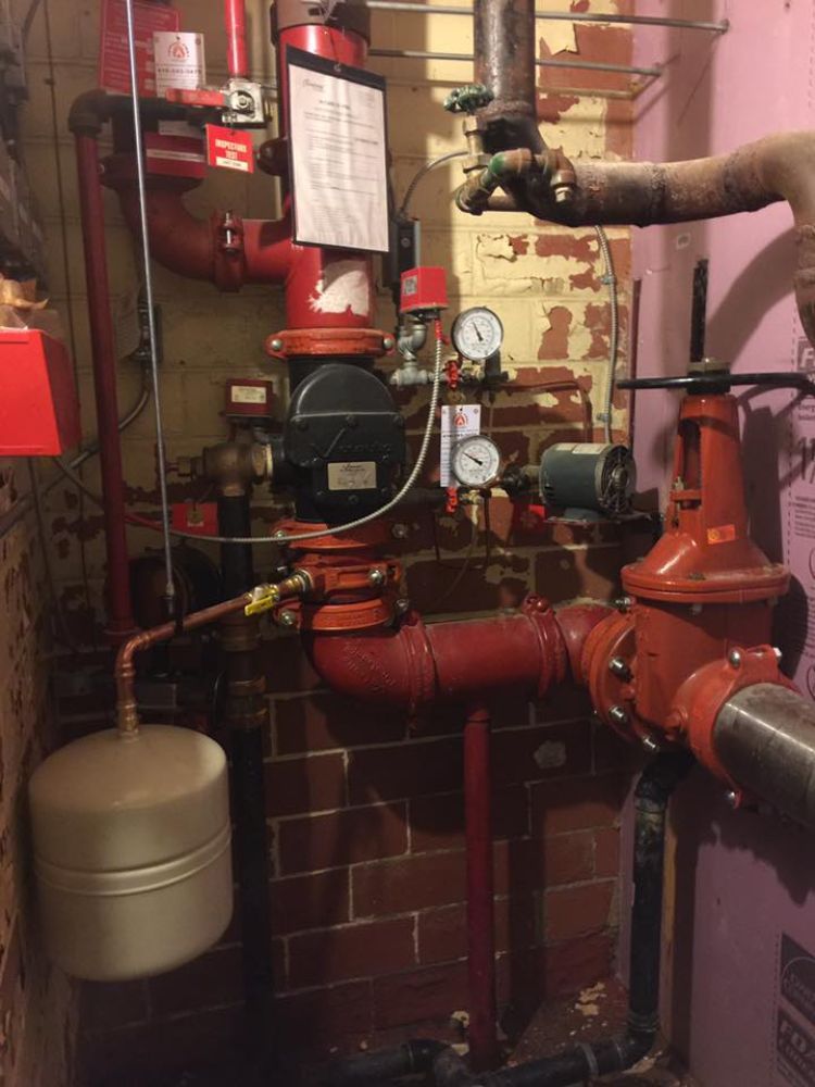 A room with a lot of red pipes and valves
