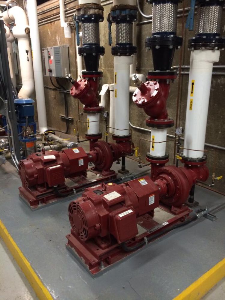 Three red pumps are sitting next to each other in a room.