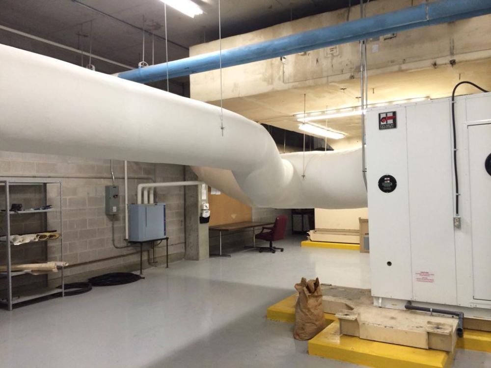 A room with a lot of pipes hanging from the ceiling