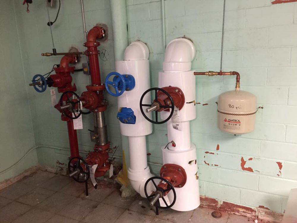 A room with a lot of pipes and valves on the wall.