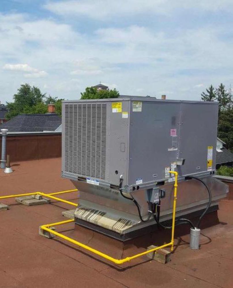 A large air conditioner is sitting on top of a roof.
