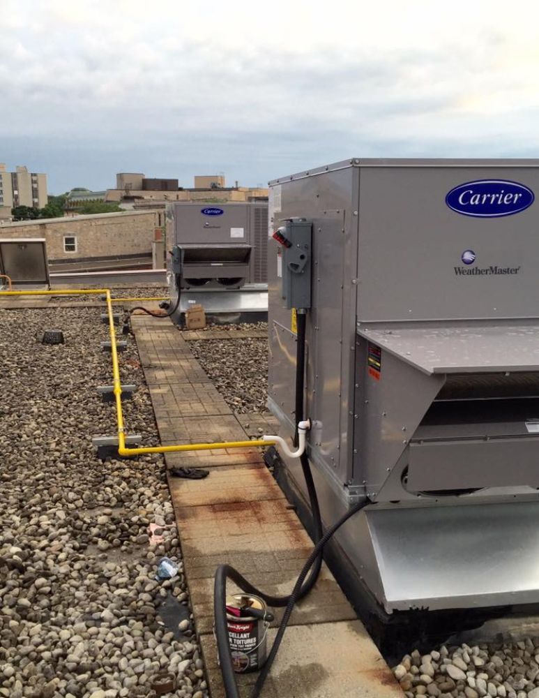 A carrier air conditioner is on the roof of a building