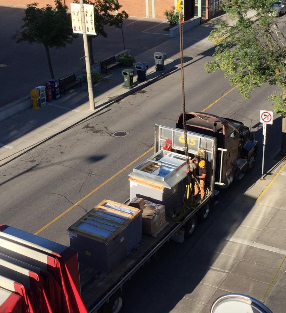 A truck is parked on the side of the road with a no parking sign