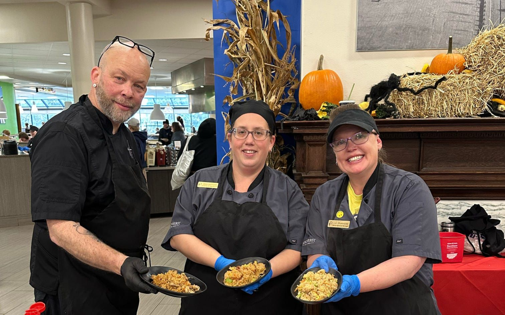 A man in a chef 's hat is posing for a picture with two other chefs