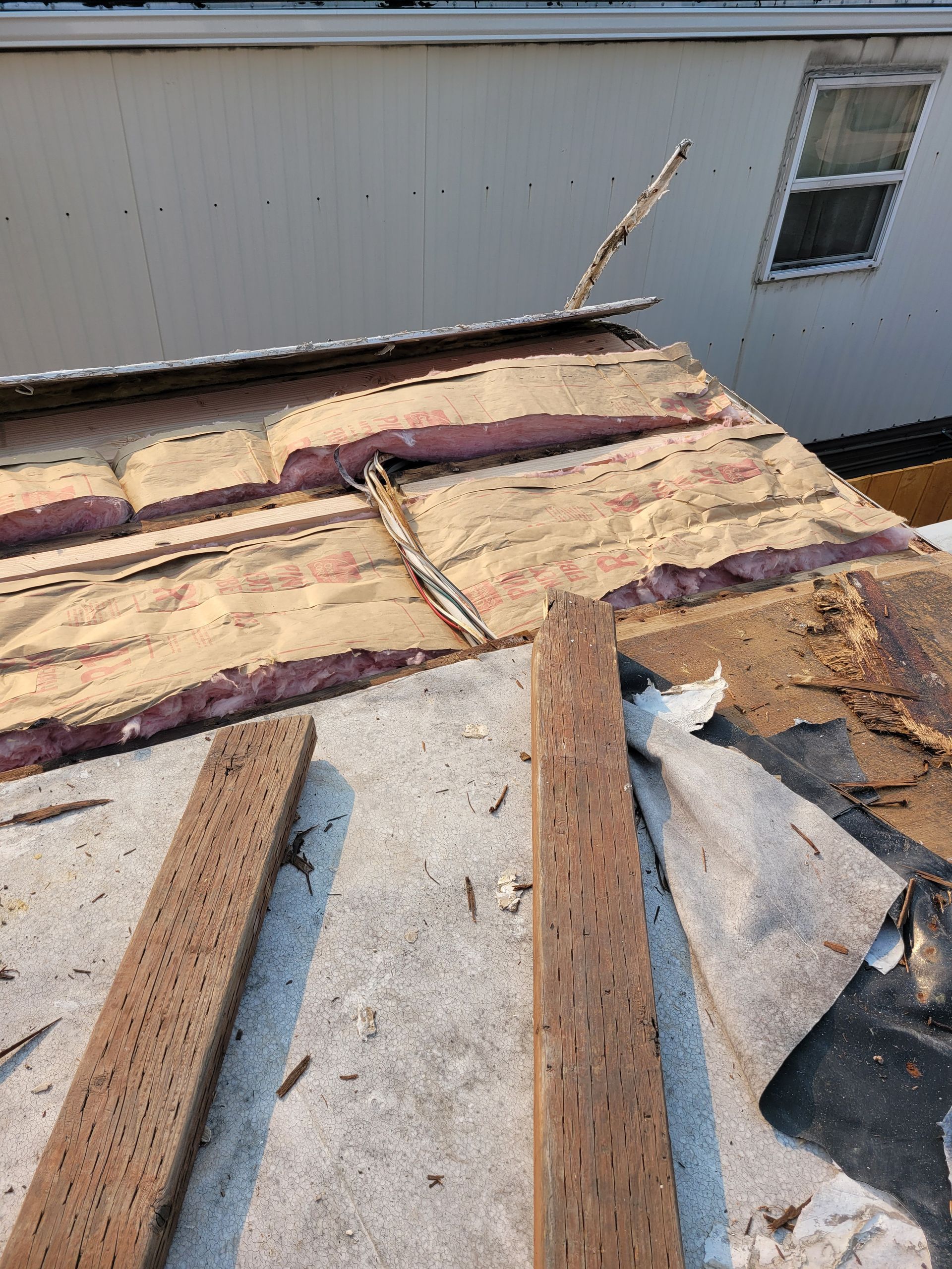 A roof with a lot of wood on it is being repaired.