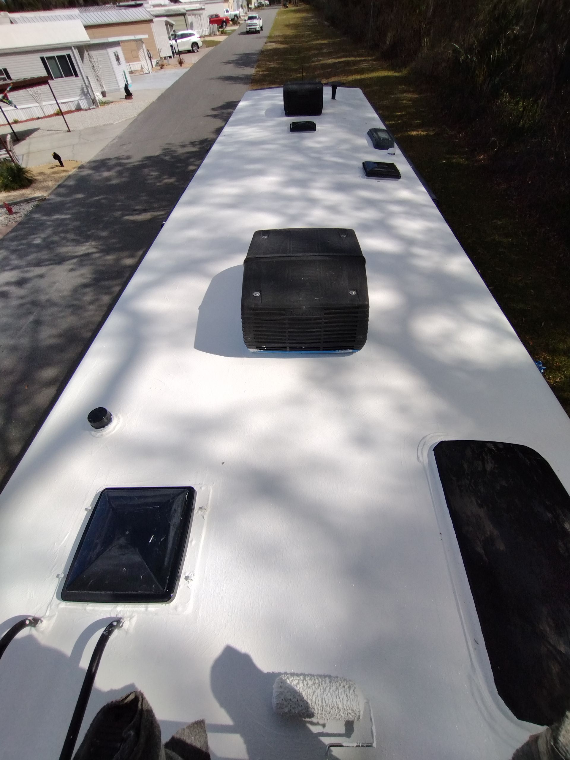 A white bus is parked on the side of the road