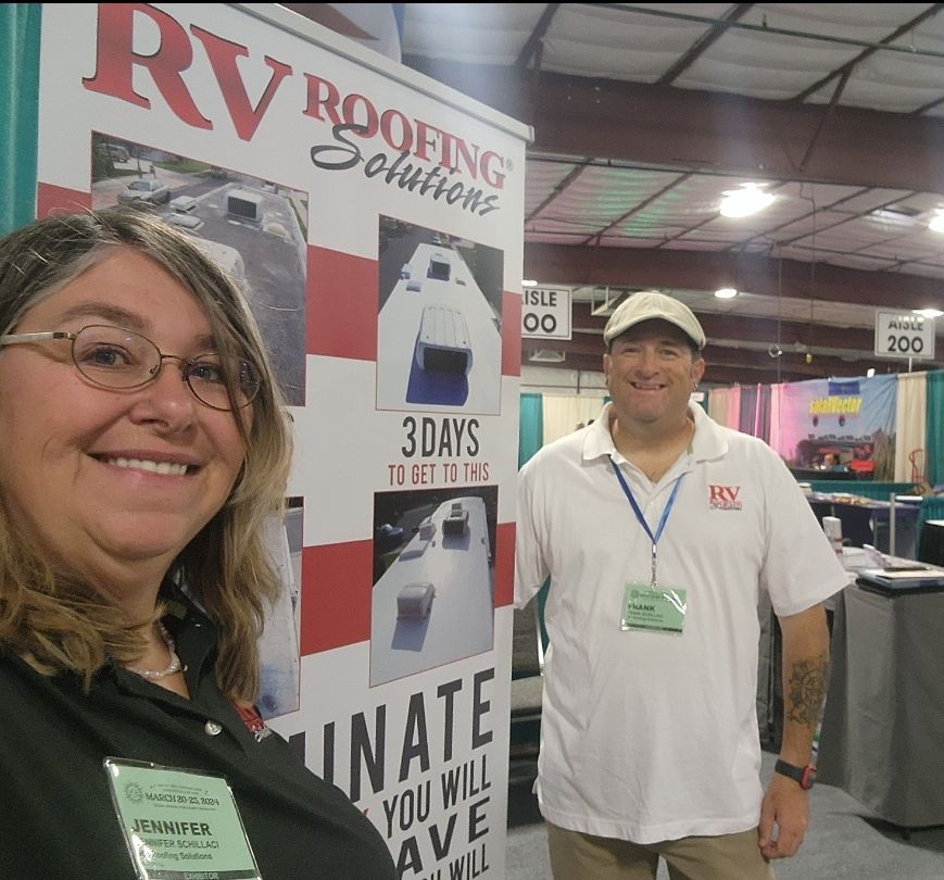 A man and a woman standing in front of a sign that says RV Roofing Solutions.