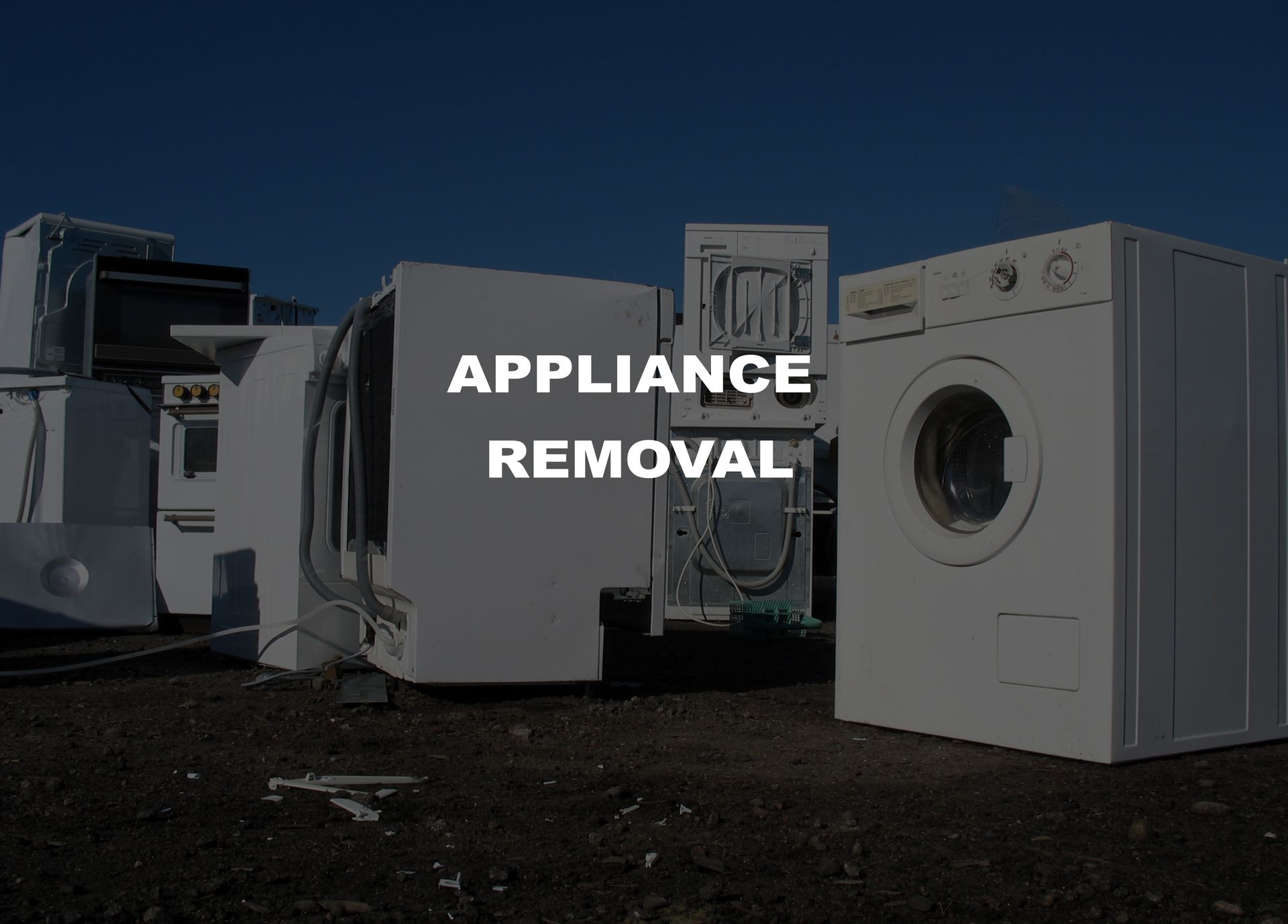 Pile of old appliances, including a washing machine, with