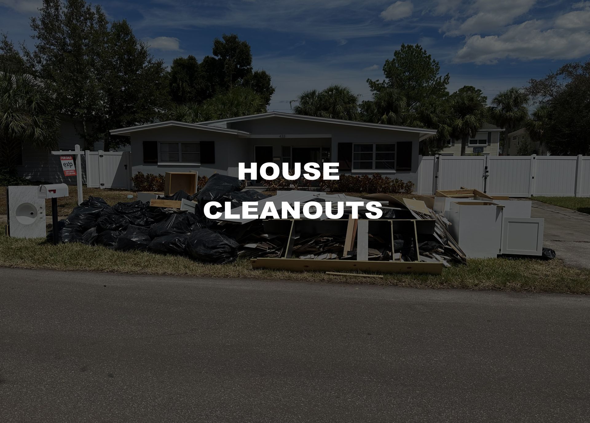 A house with trash pile in front.