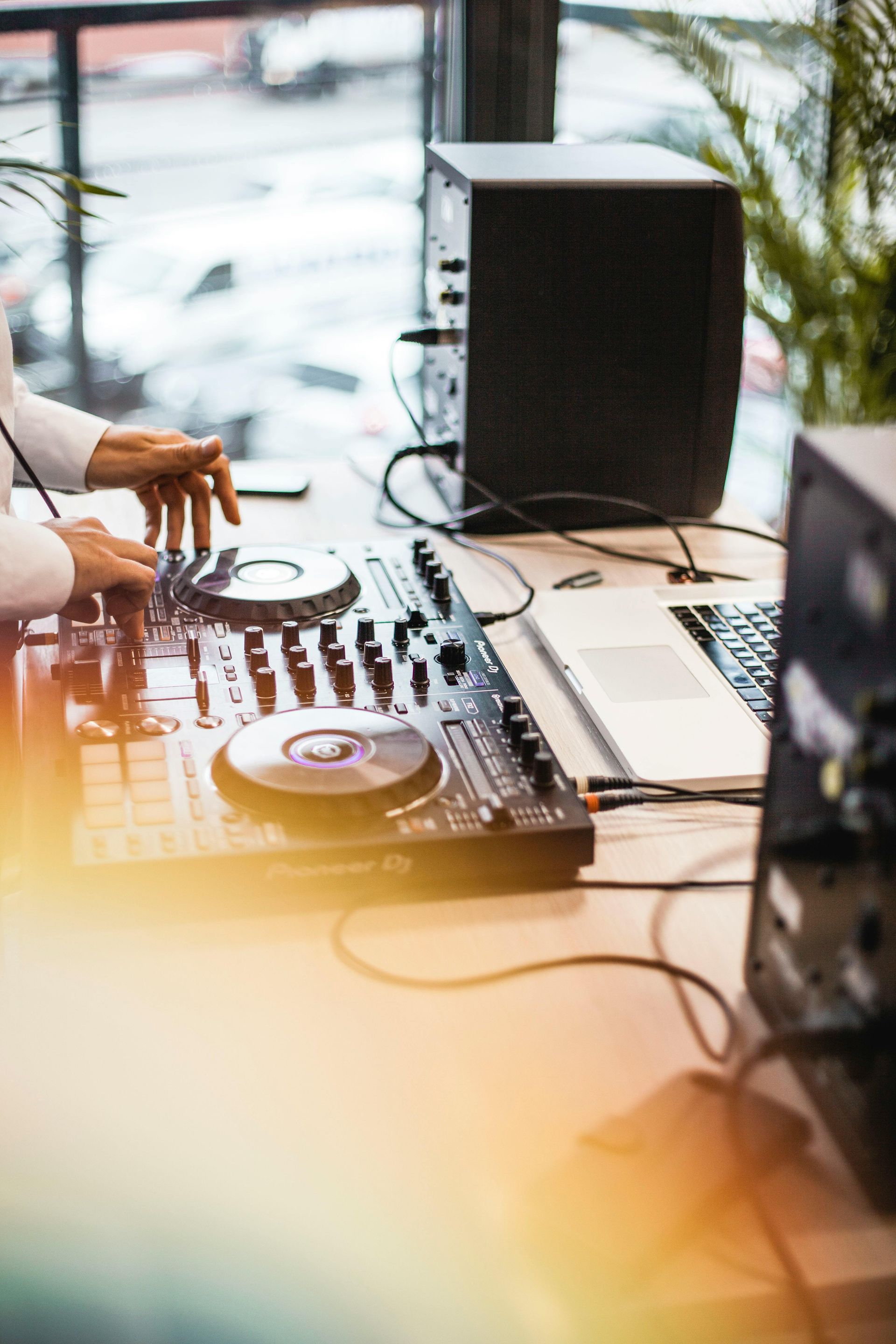 A dj is playing music on a mixer at a party.