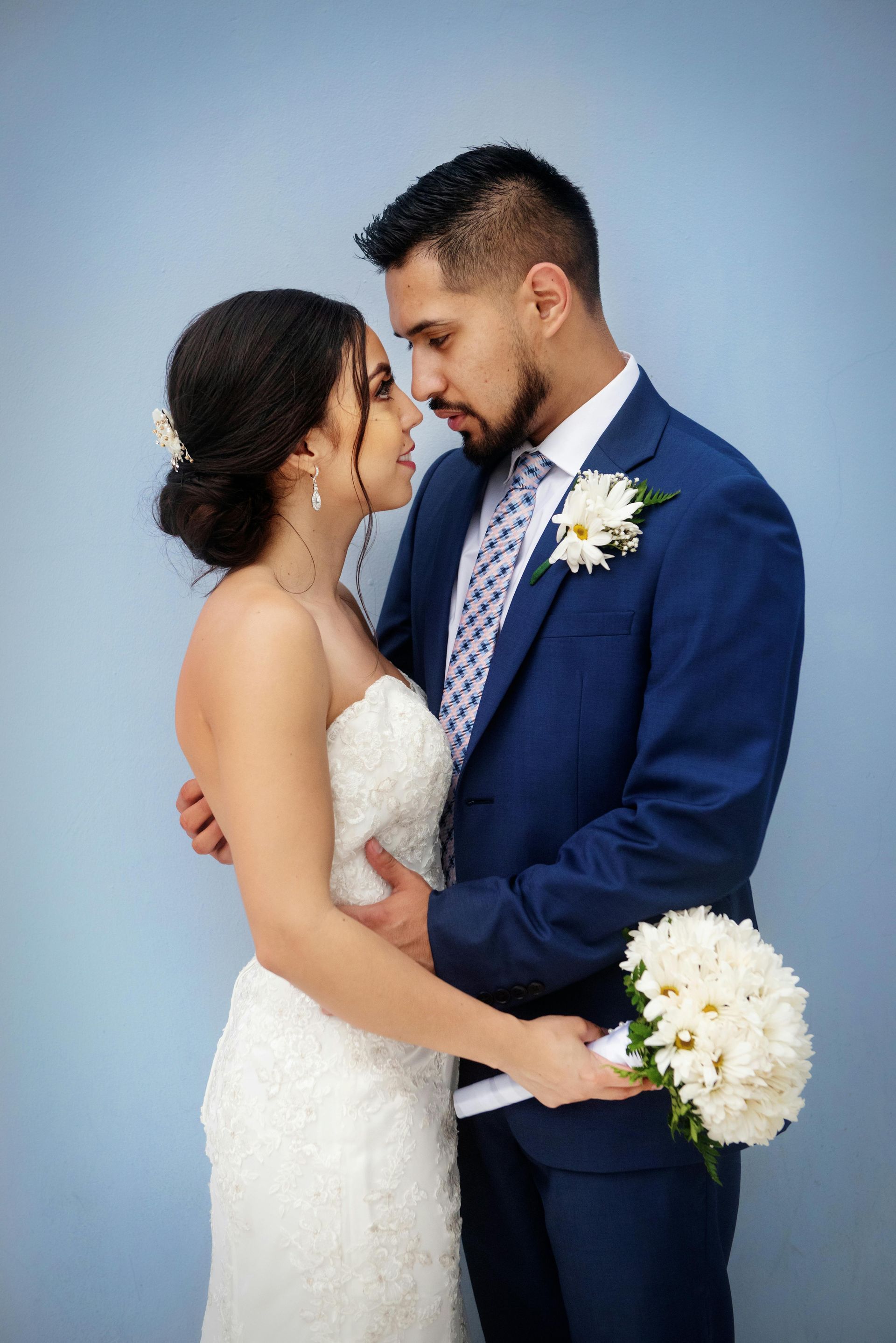 A bride and groom are posing for a picture on their wedding day.