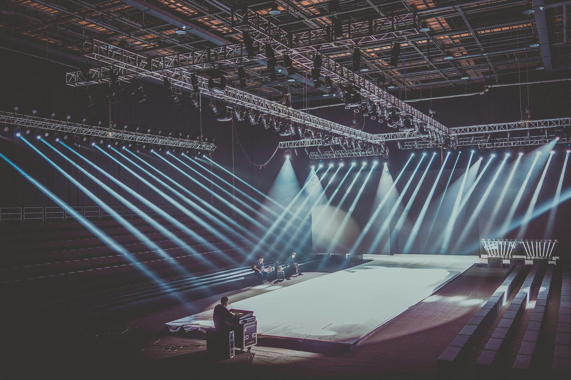 A man is standing in front of a stage with a lot of lights on it.