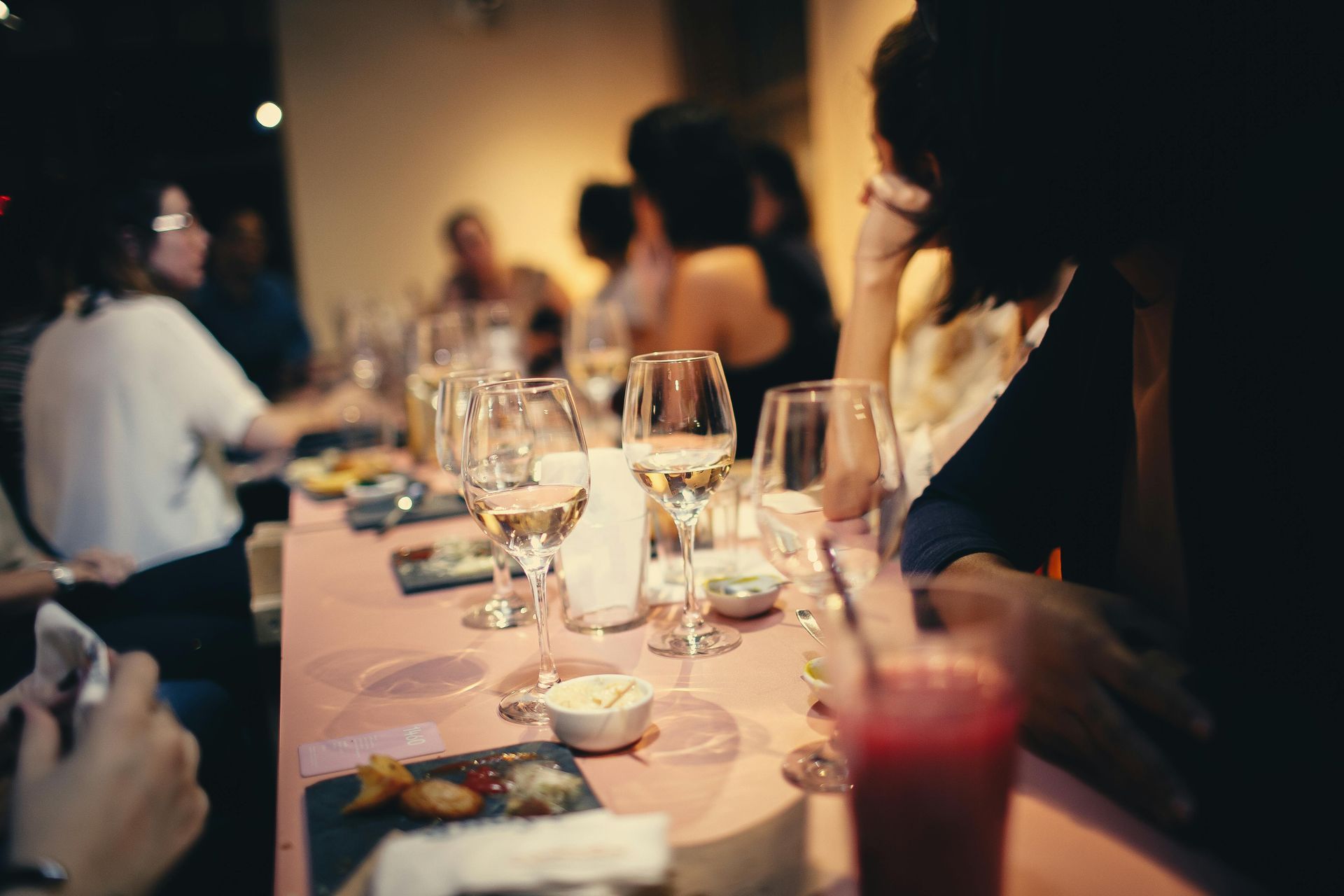 A group of people are sitting at a long table with wine glasses.