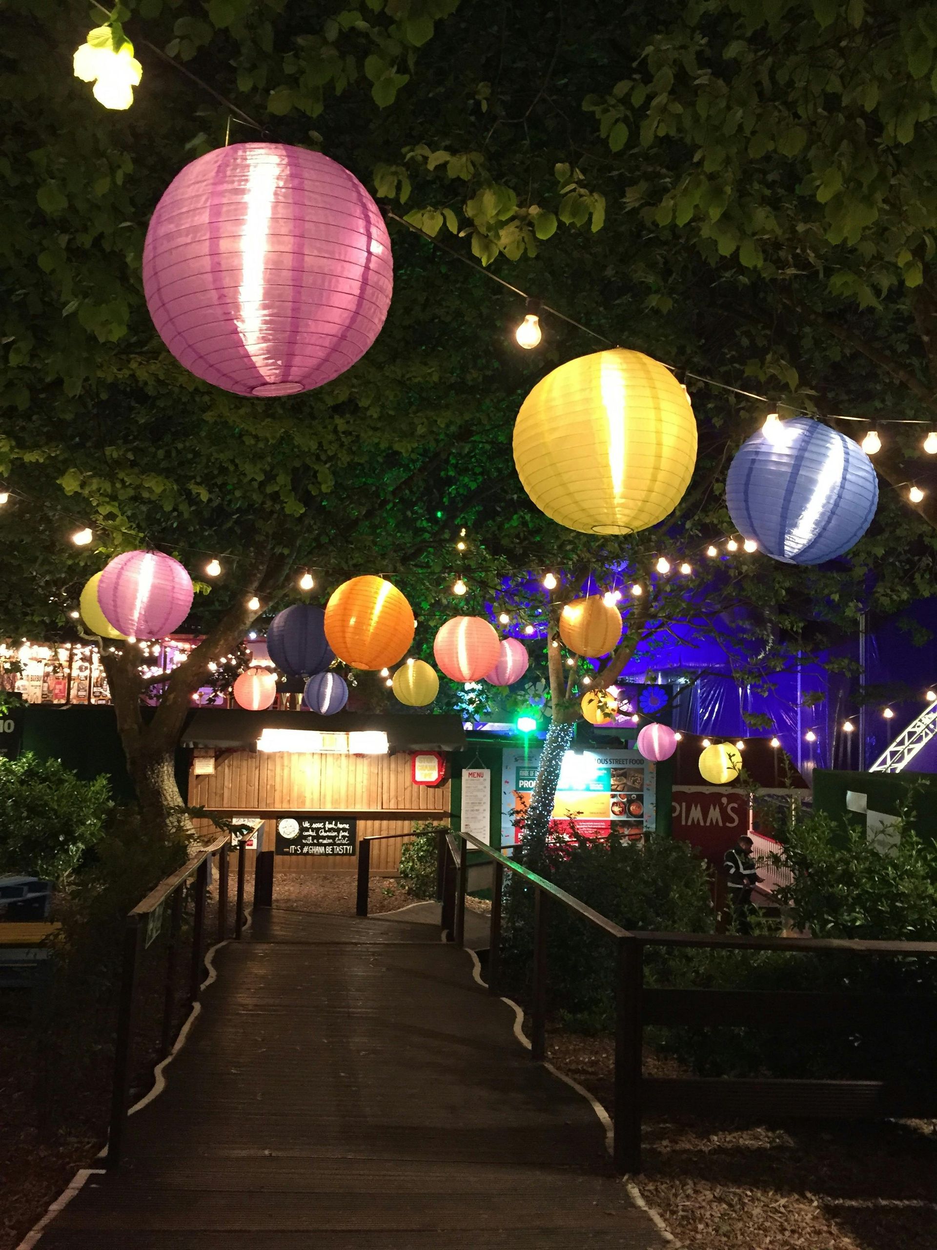 A bunch of colorful lanterns are hanging from trees