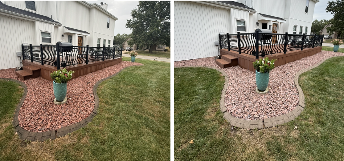 A white house with a brown deck, black railings, and a red rock landscape border featuring a teal planter on the lawn.