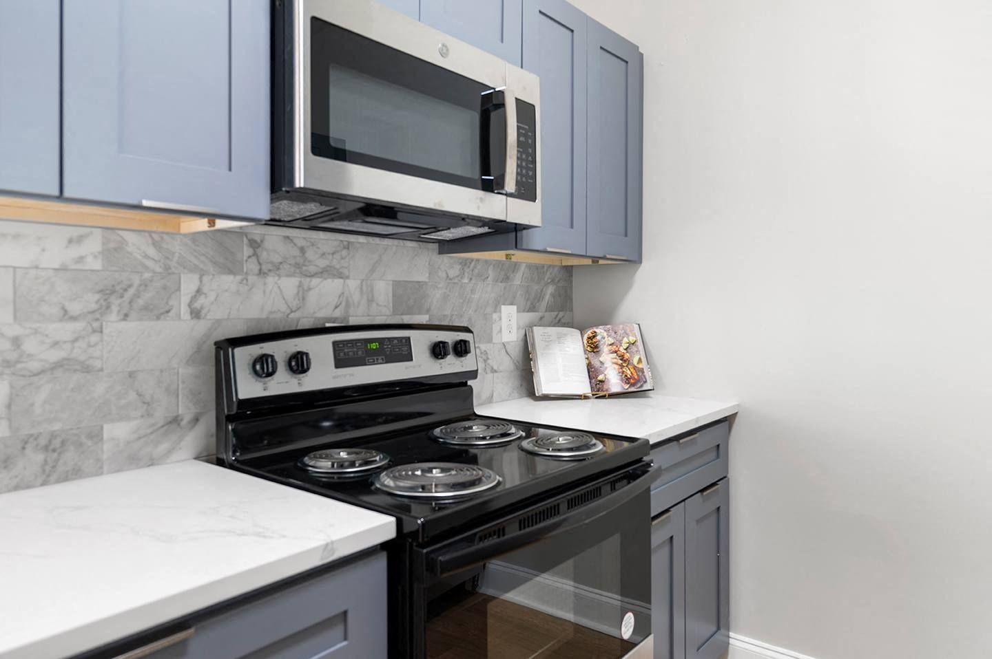 Modern kitchen with black stove and microwave.