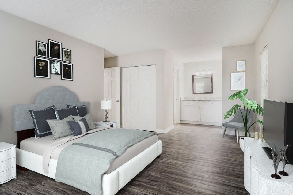 Spacious bedroom featuring a bed, nightstand, and decorative items on the walls.