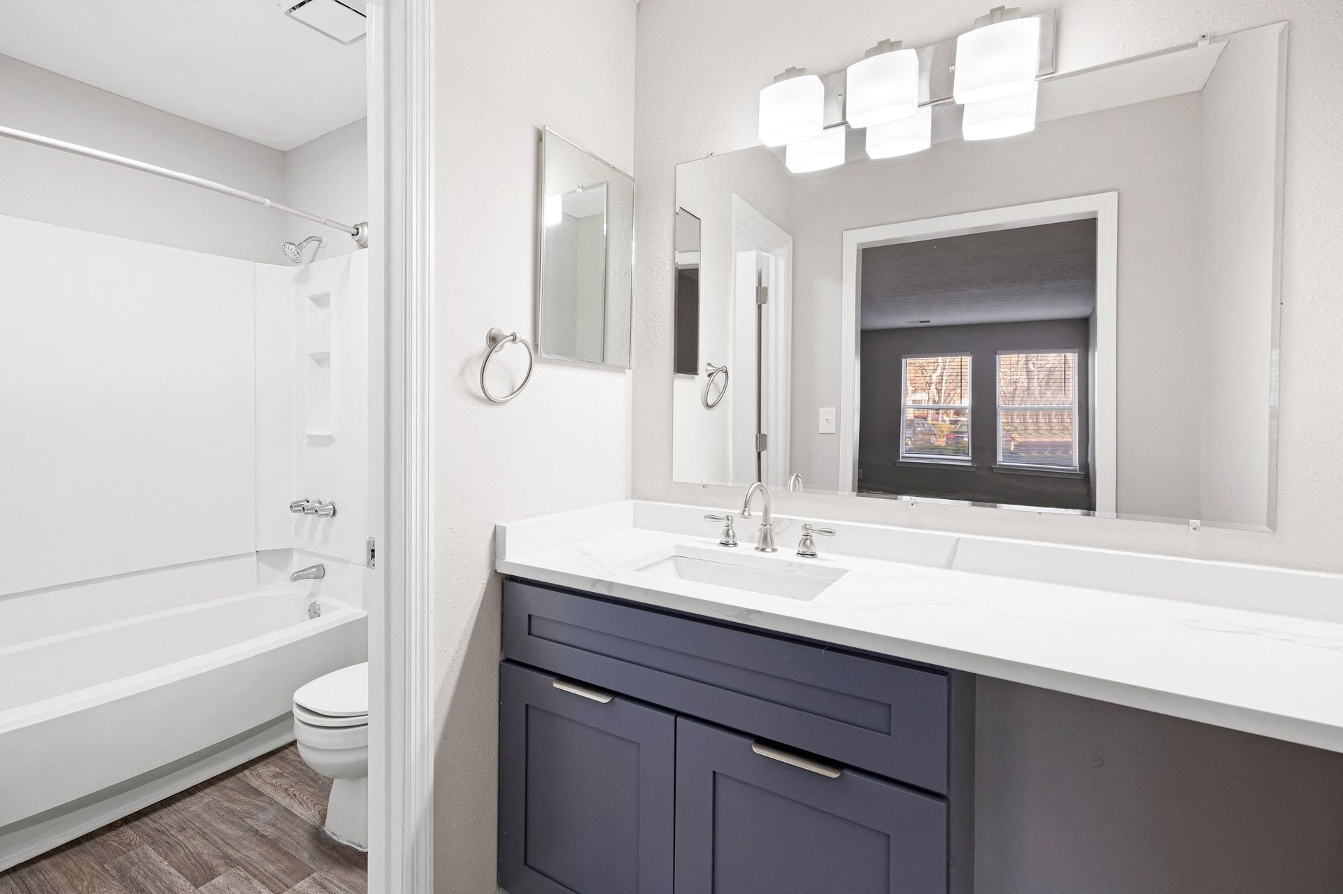 Modern bathroom with a bathtub, sink, and mirrors.