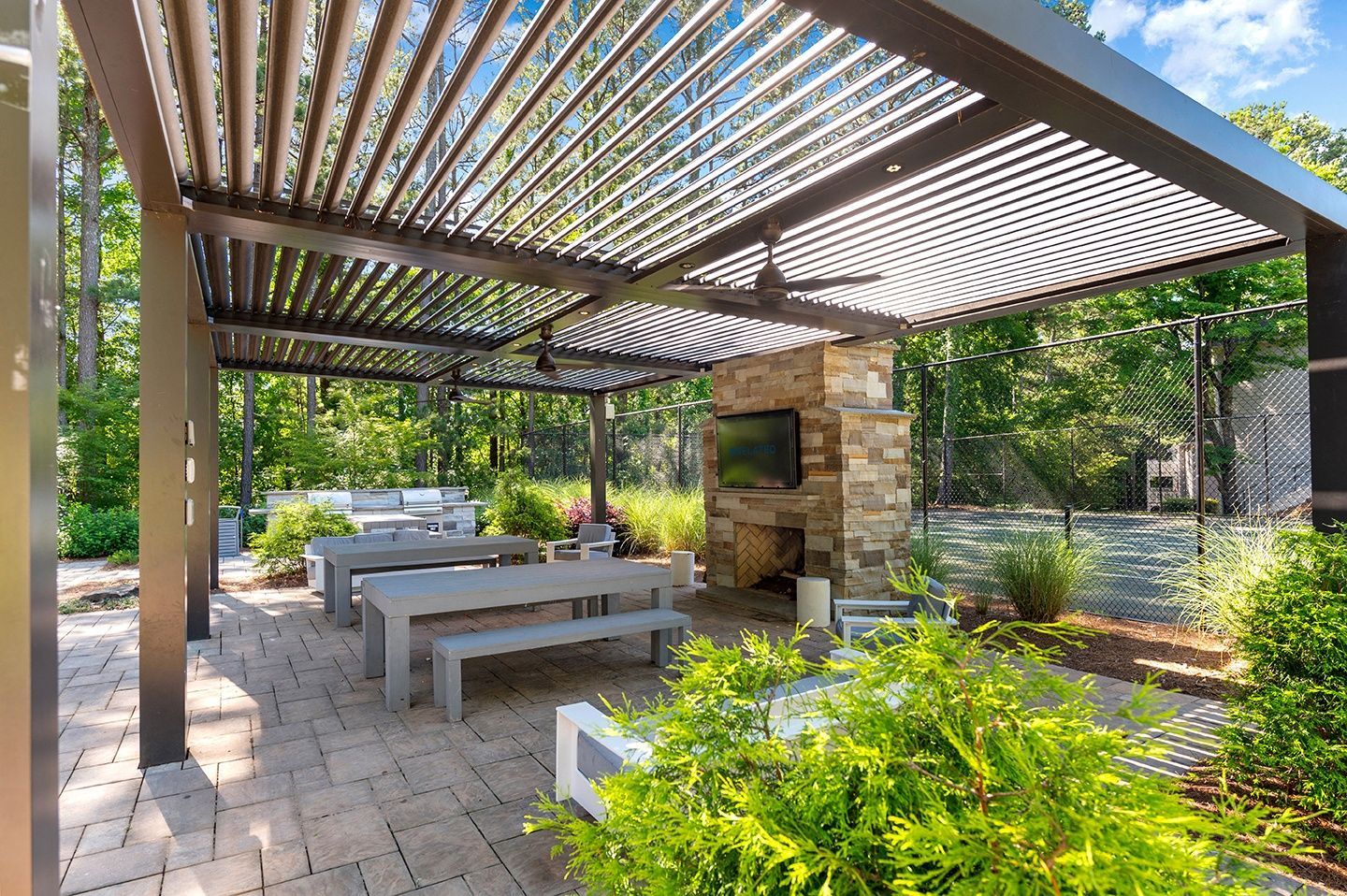Outdoor community gathering space with seating and a fireplace.