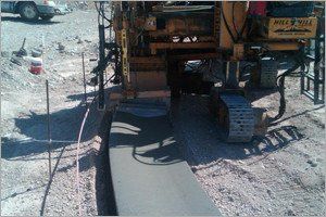 Concrete being poured by a machine at a construction site.