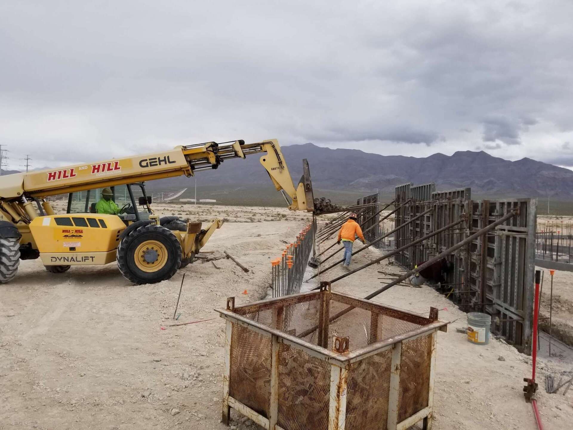 Construction site with a telehandler pouring concrete into forms
