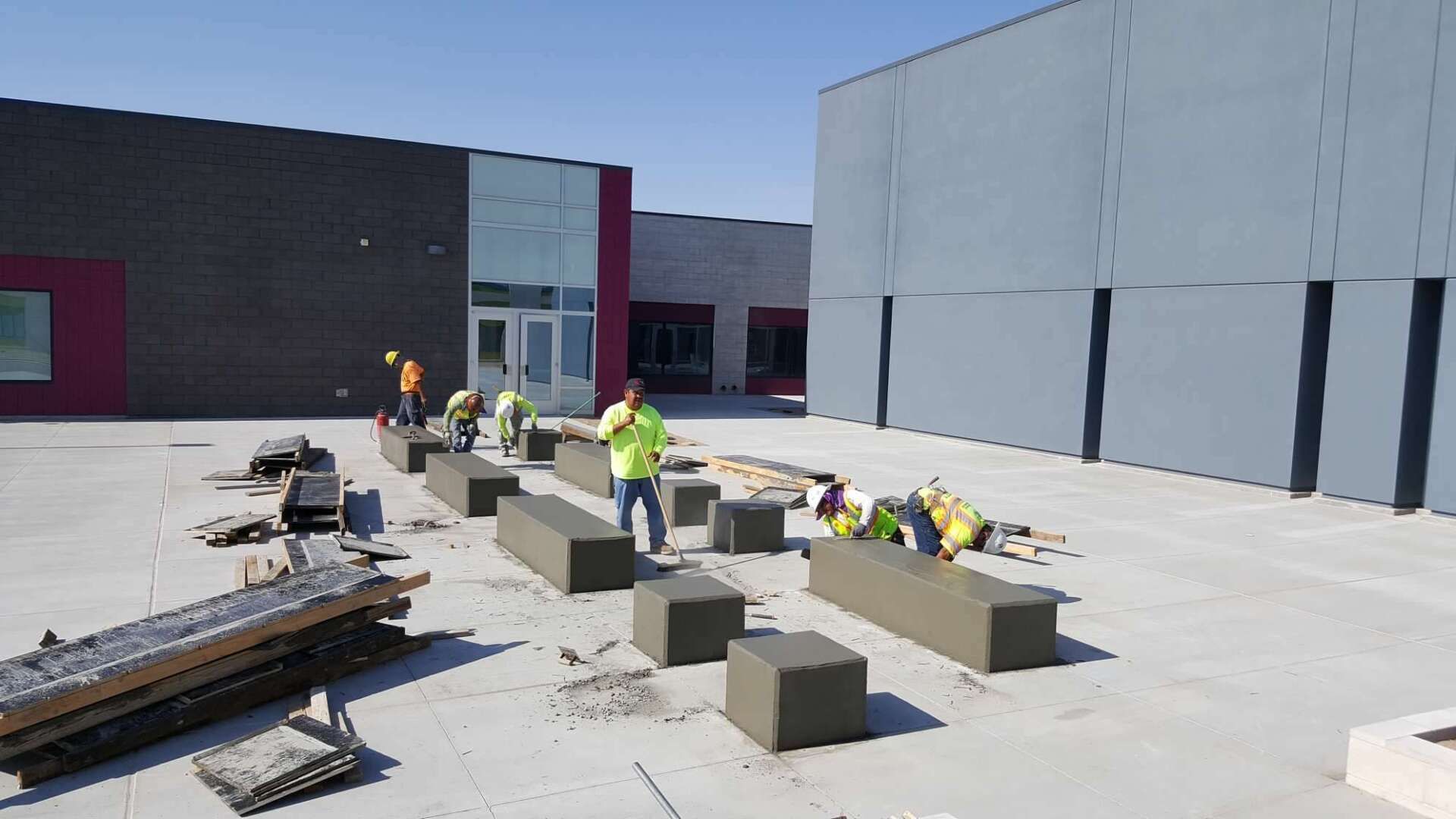 Construction workers install concrete seating on a building's exterior.