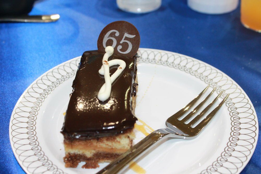 A slice of birthday cake for an individual's 65th birthday.