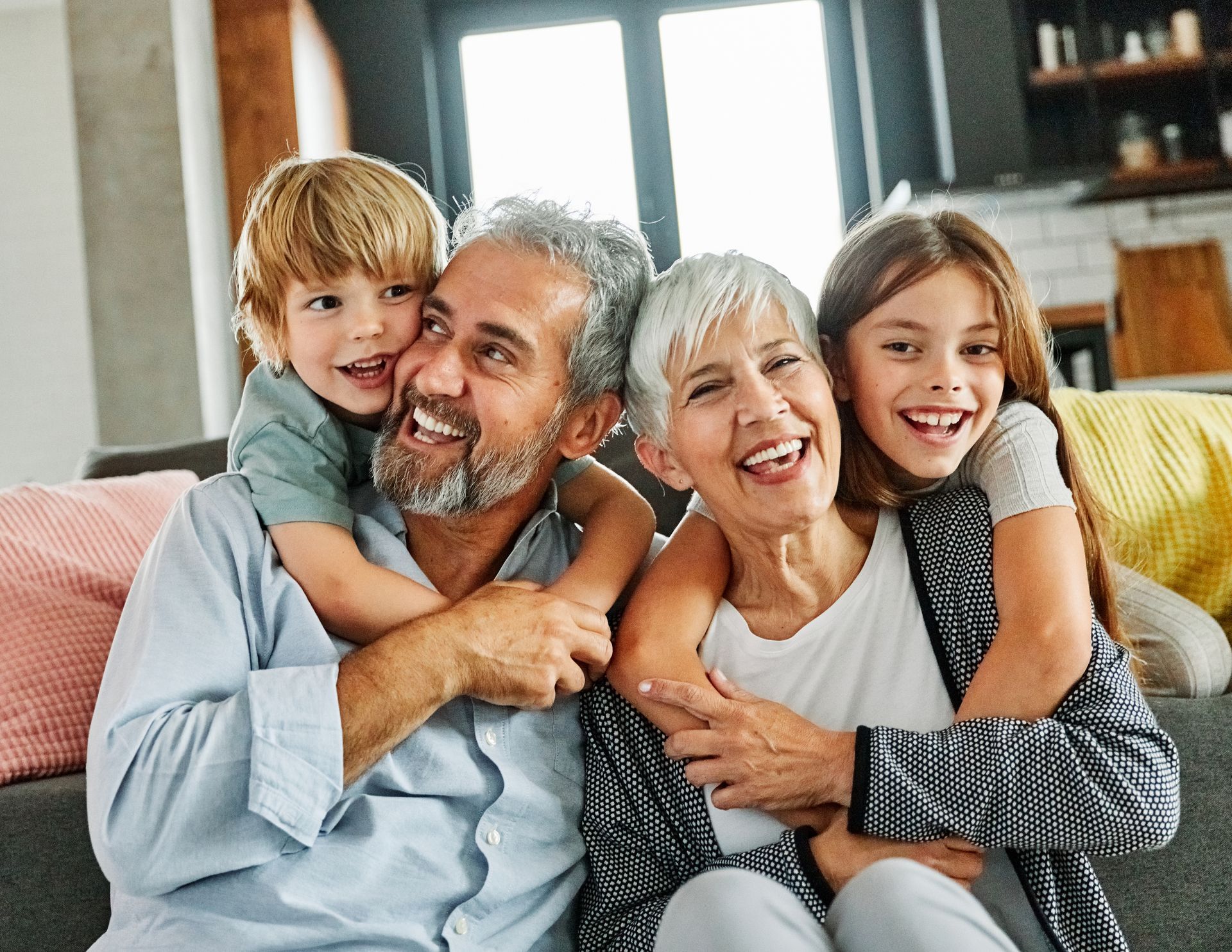 Grandchildren hugging their grandparents from behind