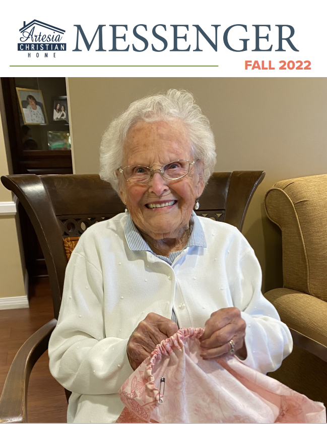 Arizona Christian Home Messenger magazine cover. An elderly woman smiles, knitting in a living room. Fall 2022.