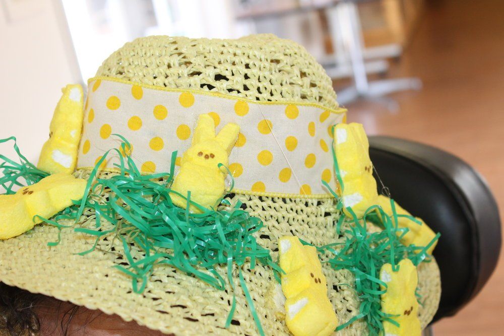 Yellow Easter hat decorated with yellow Peeps, green grass, and polka dot ribbon.