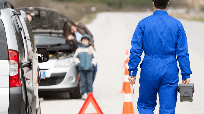 roadside mechanic walking to a broken down car