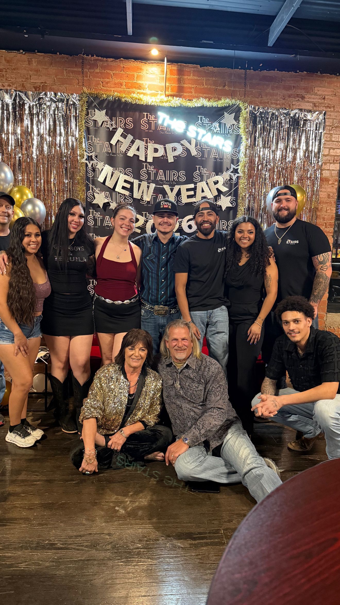 The staff is standing in front of a red couch on New Year’s Eve.