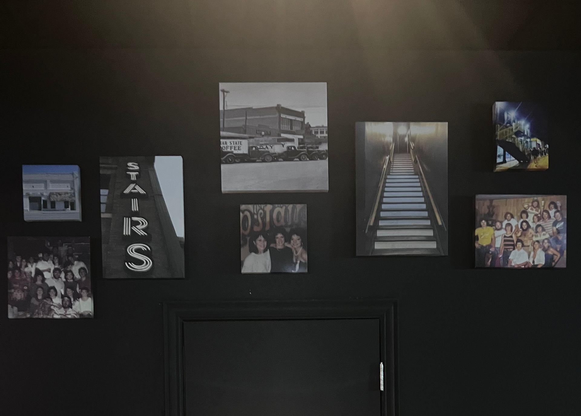 A black wall with a bunch of pictures on it