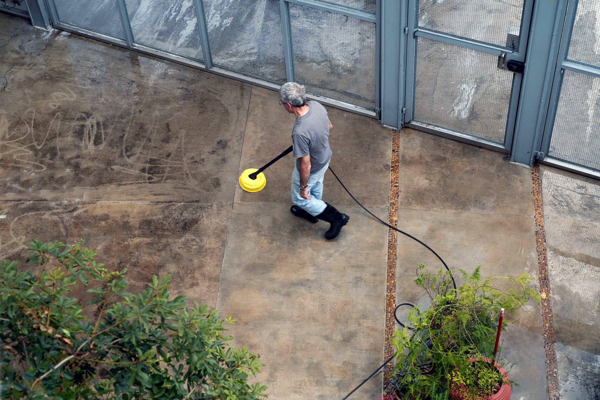 A man is cleaning a concrete floor with a machine