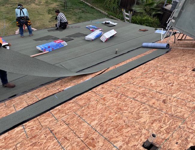 Men installing low slope roofing — Rio Linda, CA — M1 Roofing