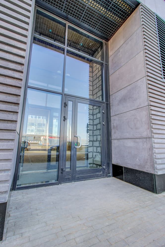 A Building With a Large Glass Door and a Brick Wall — Pelican Glass in Swansea, NSW