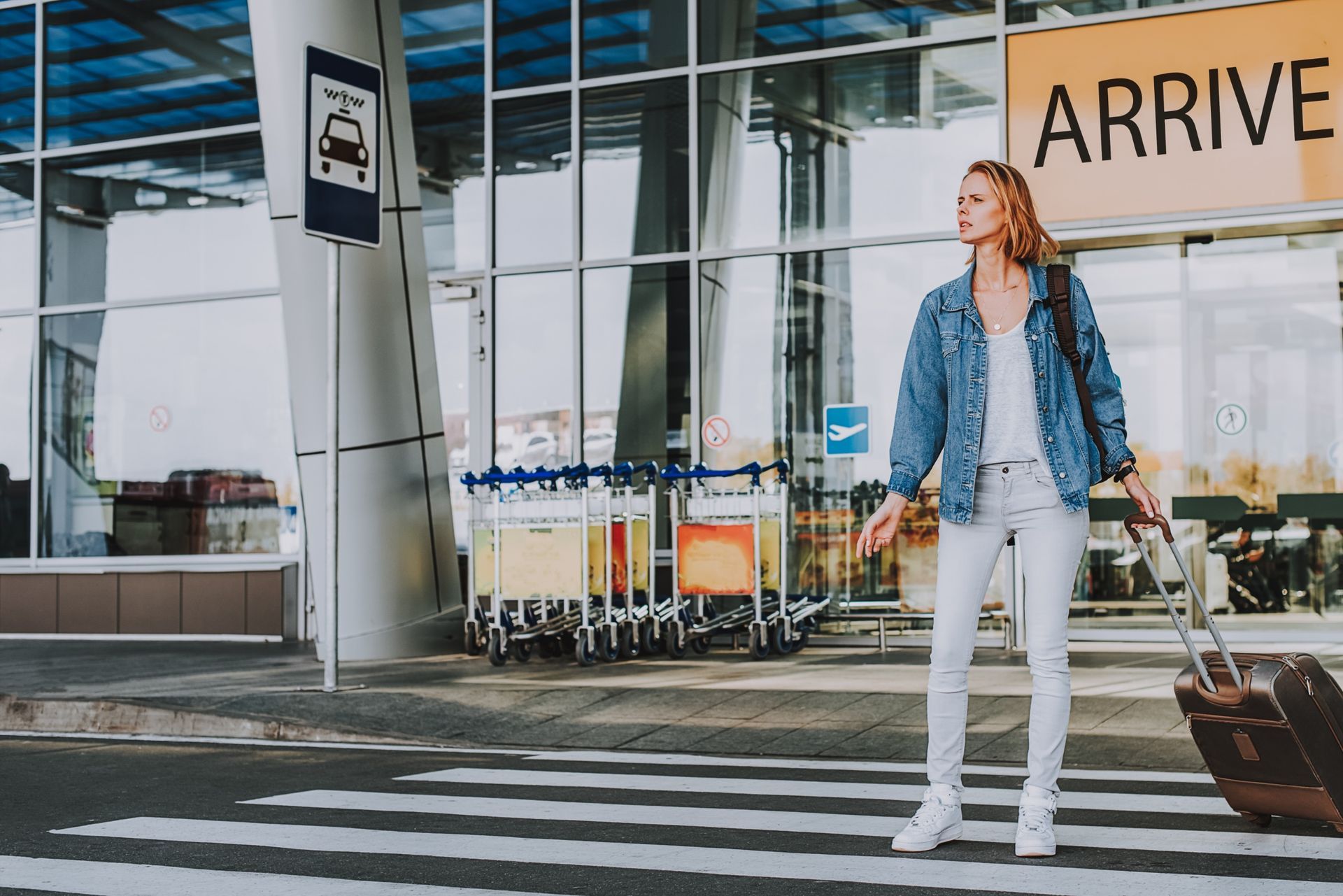 Woman with rolling suitcase at airport 