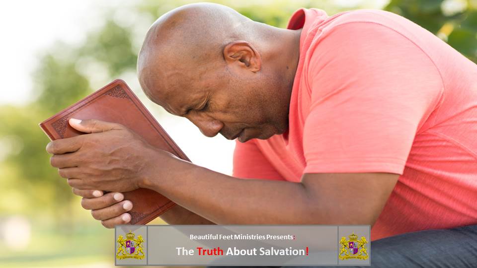 A man is kneeling down with his head down while holding a bible.