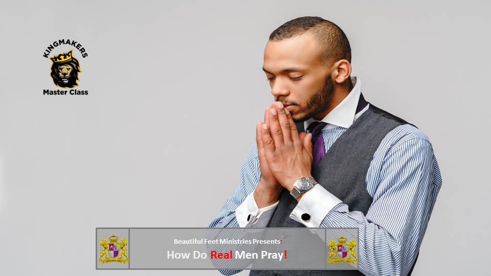 A man in a suit and tie is praying with his hands folded.
