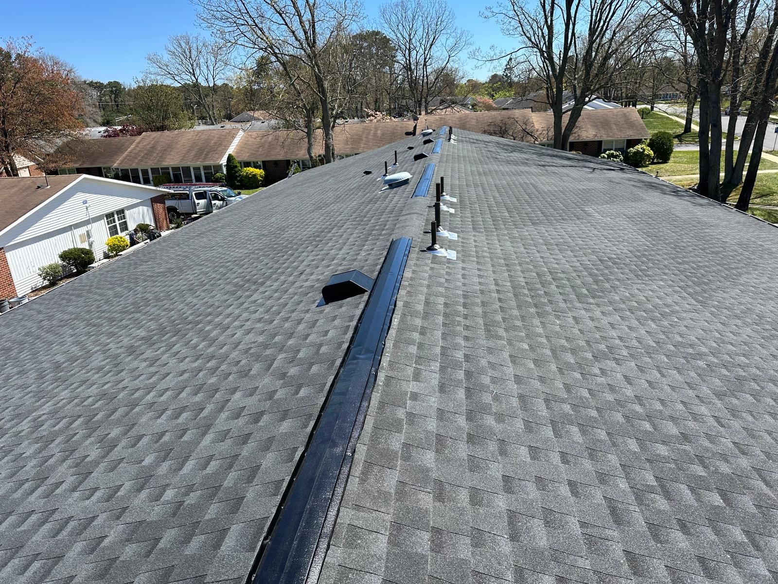 An Aerial View of a Roof With a Lot of Shingles and Trees in the Background — Burlington, NJ — AD Roofer Siding & Gutters