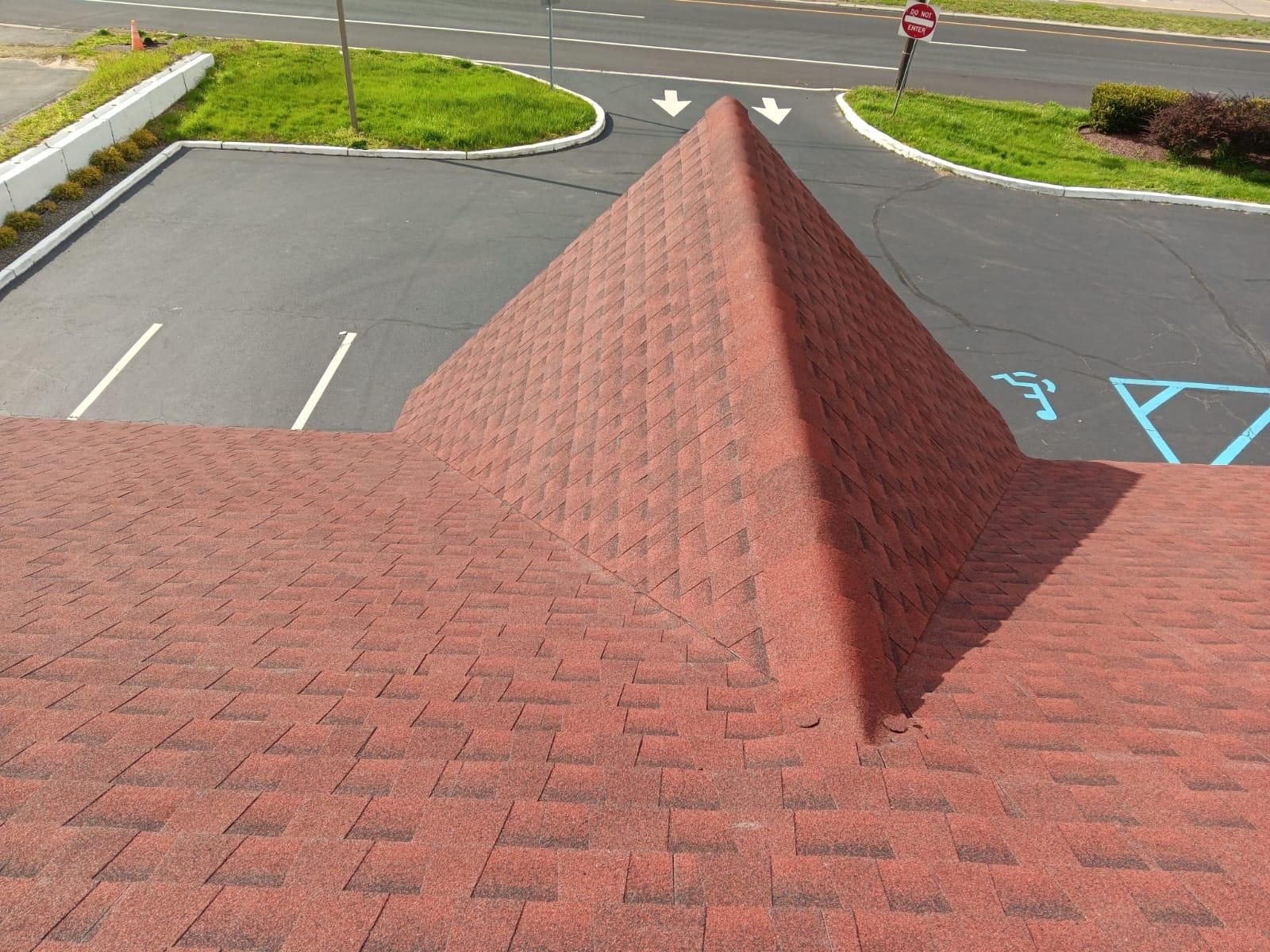 A Red Pyramid Shaped Roof in a Parking Lot — Burlington, NJ — AD Roofer Siding & Gutters